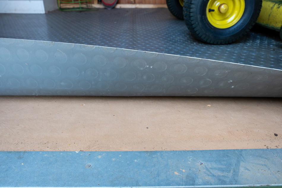 Lifting protective flooring up to show shed floor